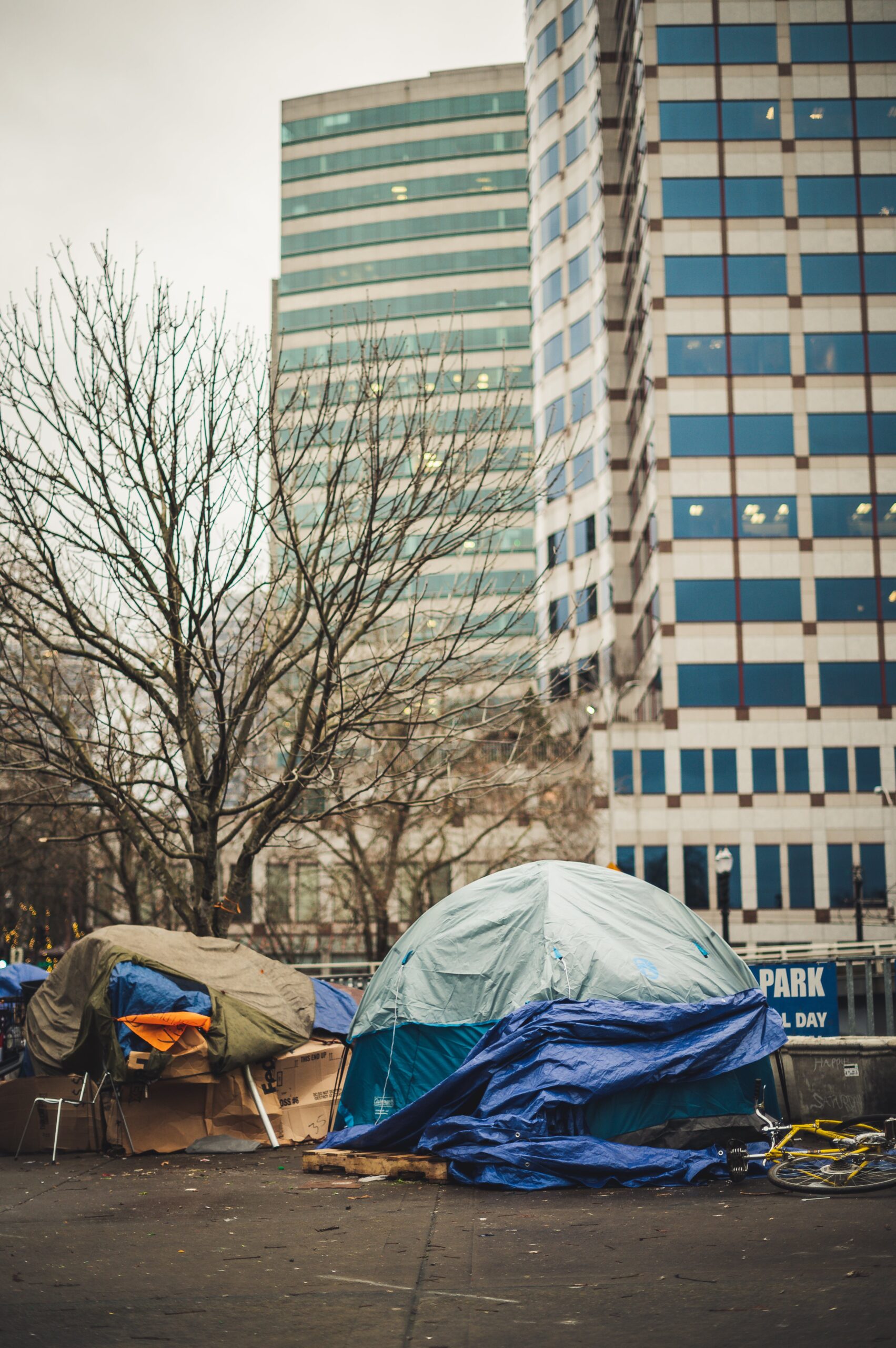 Tents on city street in front of two tall buildings